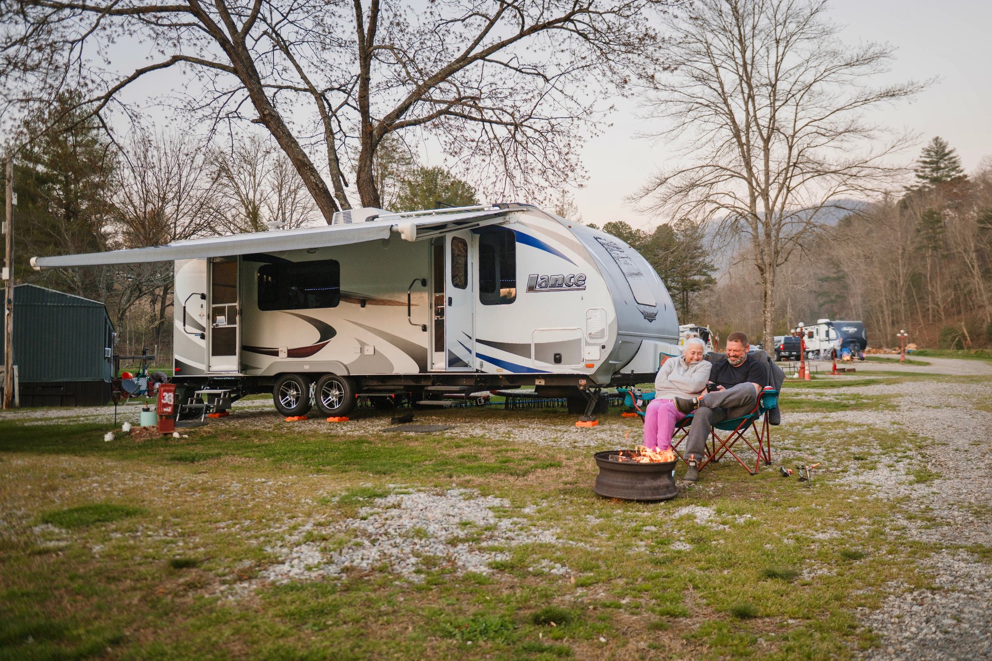 Guests relaxing by a fire outside their RV at Skeenah Creek Campground & Mill in Suches, Georgia Guests relaxing by a fire outside their RV at Skeenah Creek Campground & Mill in Suches, Georgia